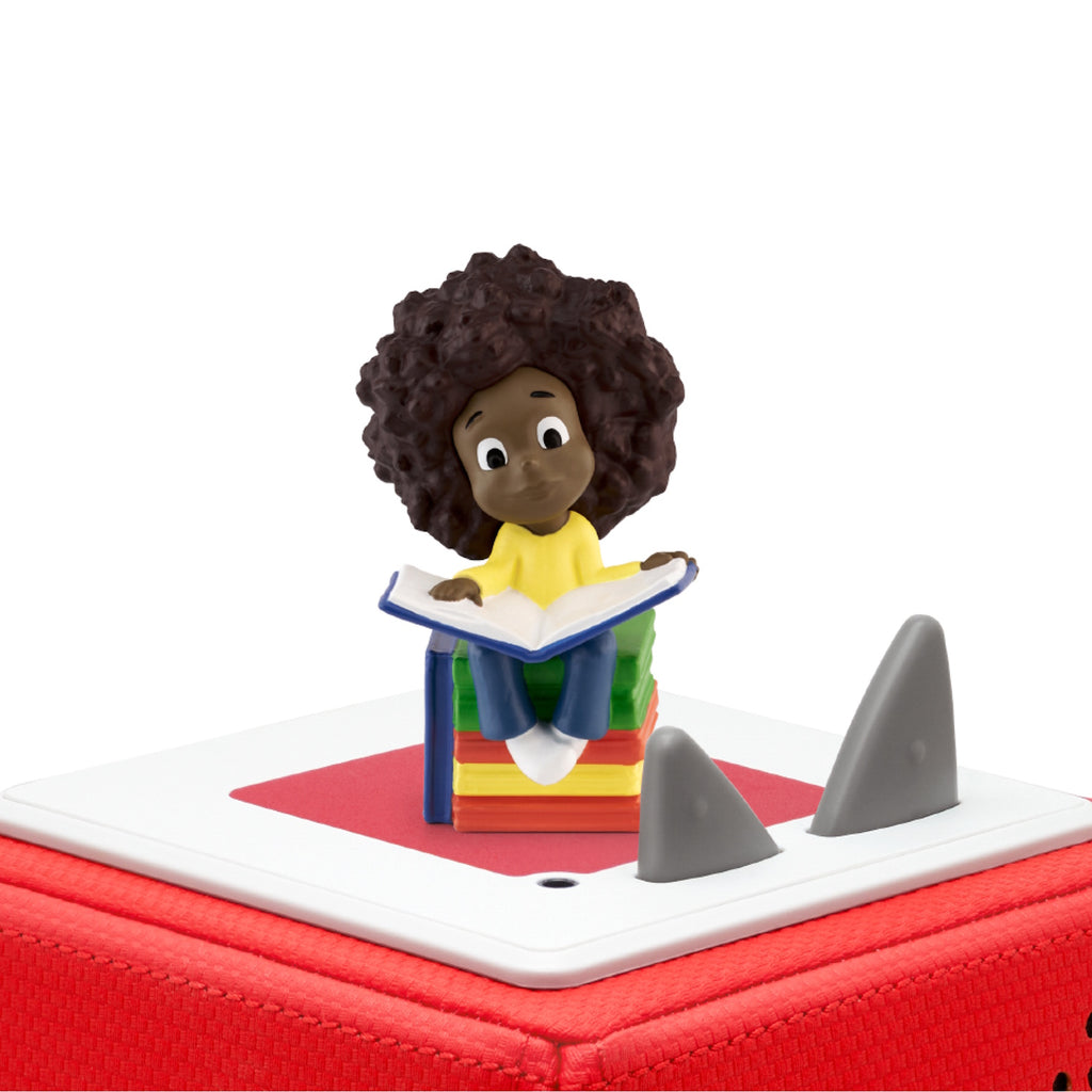 A child with curly hair reads on a stack of colorful books.