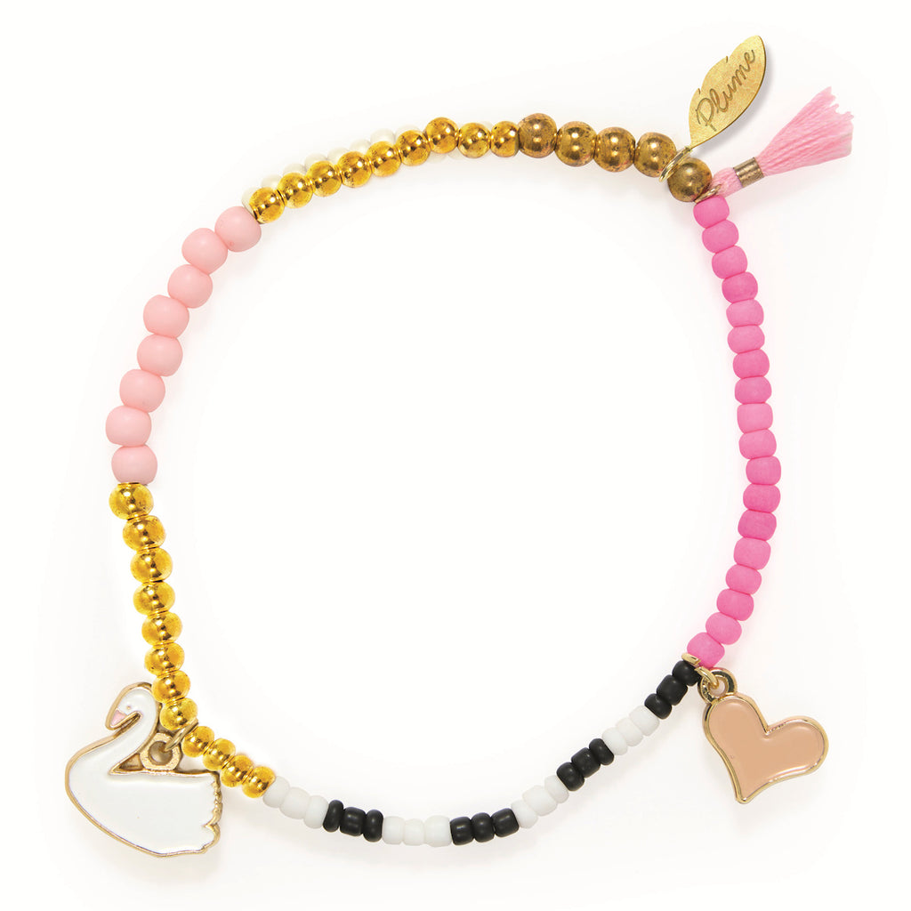 A beaded bracelet with a mix of gold, pink, and black beads, featuring a swan charm on one side and a heart charm on the other, exuding a playful and elegant tone.