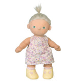 Dinkum Doll with blonde hair wearing a pink floral Suki dress and yellow shoes.