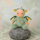 Olli Ella Dinky Dinkum Dax Dragon plush doll sitting on a rock.