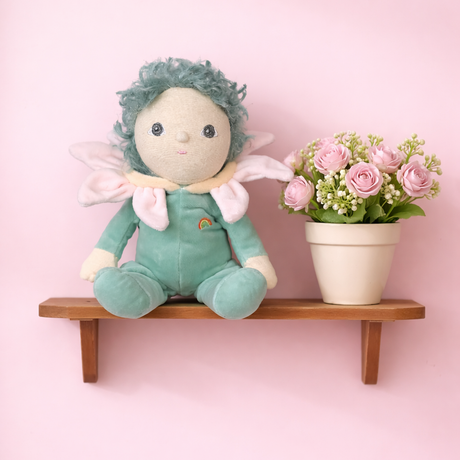 Olli Ella Dinky Dinkums Lily doll sitting on a shelf next to pink flowers.