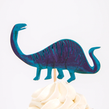 Blue long-necked dinosaur cupcake topper on a wooden pick in swirled white frosting.