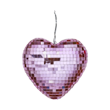 Pink heart-shaped disco ball with reflective square tiles, hanging against a white background. It conveys a festive and romantic tone.