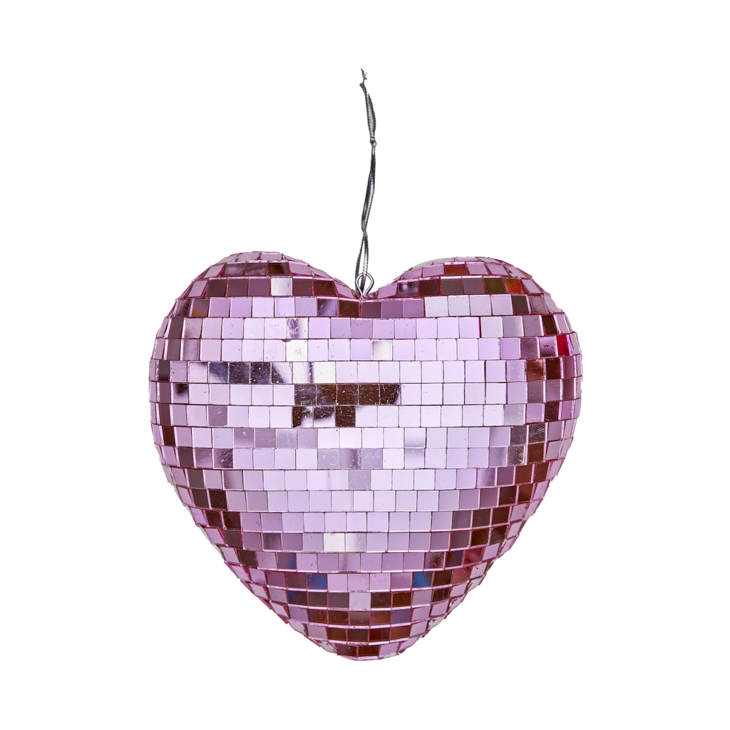 Pink heart-shaped disco ball with reflective square tiles, hanging against a white background. It conveys a festive and romantic tone.