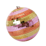 A spherical disco ball with shimmering tiles in pink, orange, and gold stripes against a white background, creating a festive and vibrant tone.