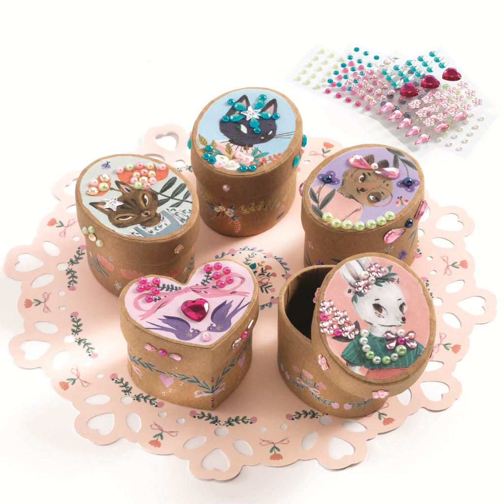 A craft kit with small, decorative boxes for kids to assemble and embellish with stickers, patterns, and colourful designs.