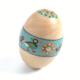 Handcrafted wooden Easter egg shaker toy with colorful bird and flower illustrations on a teal band.