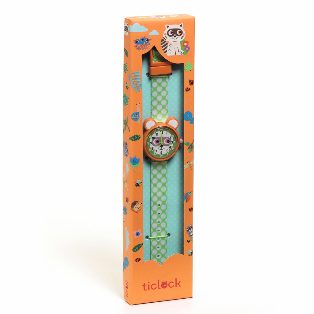 Children's watch with a green polka dot band and animal face design, packaged in an orange box decorated with playful animal illustrations.
