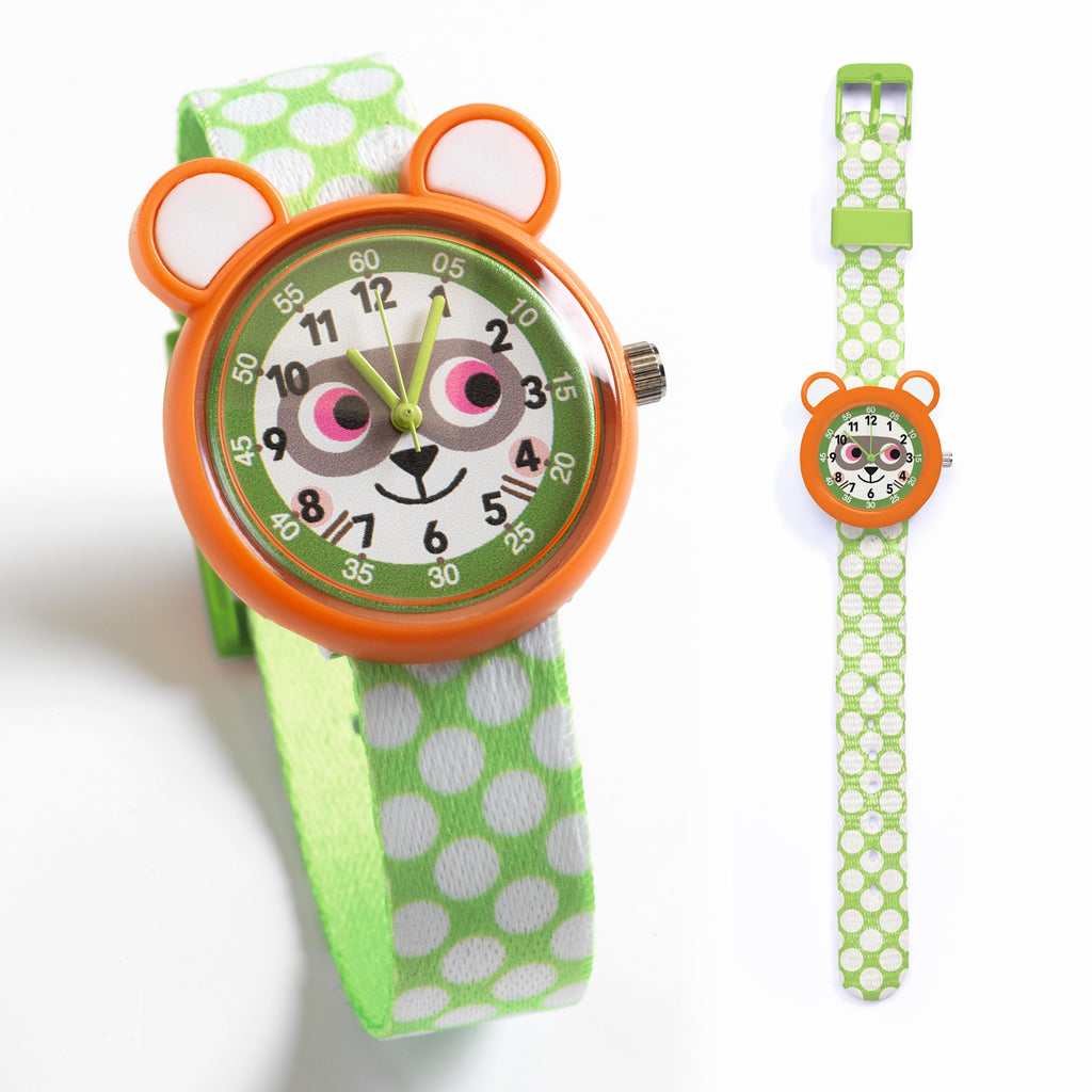 Child's watch with an orange bear face design, featuring playful pink eyes. The strap is green with white polka dots, adding a fun, lively touch.