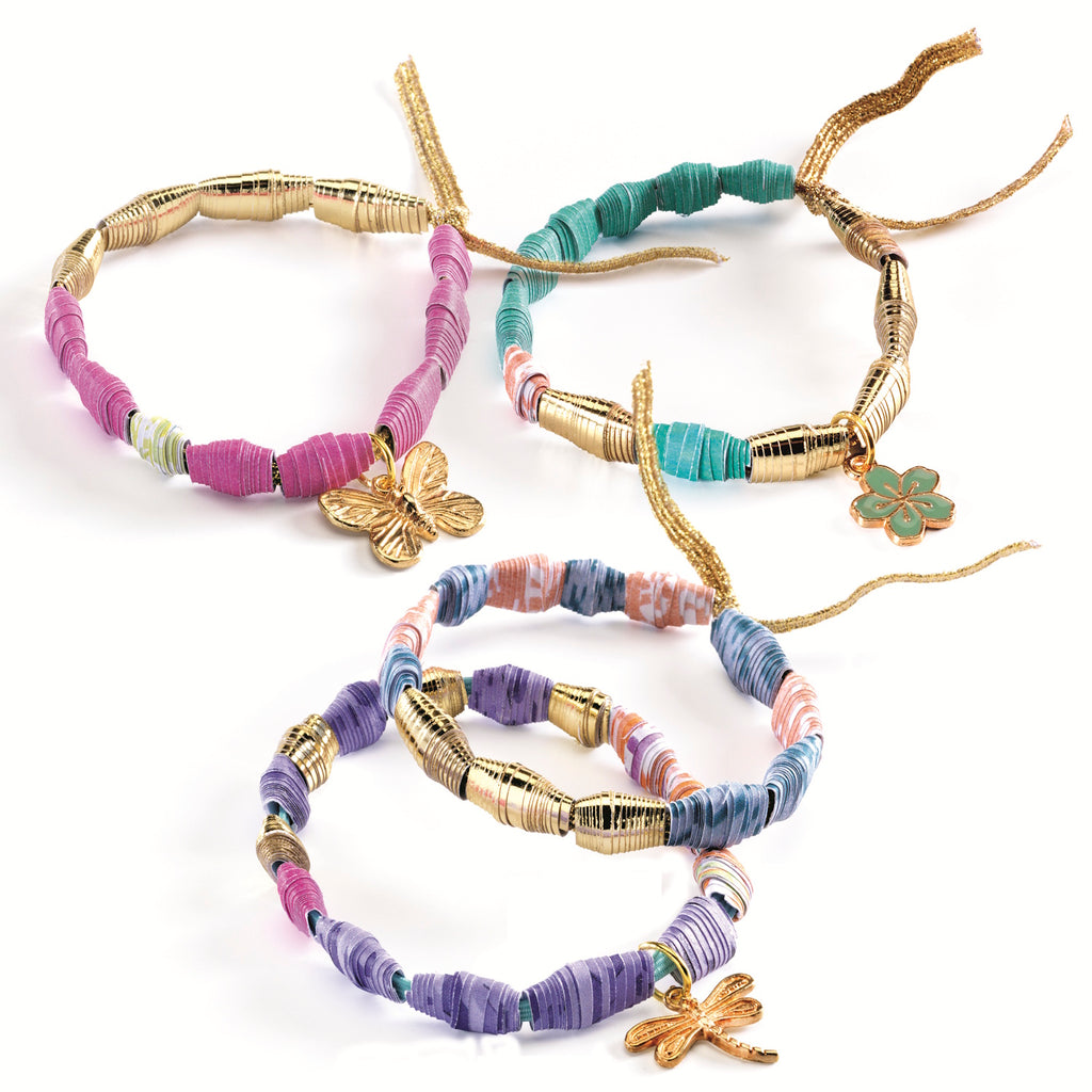 Four colorful, beaded bracelets with gold accents and charms, including a butterfly, clover, and dragonfly, arranged on a white background.