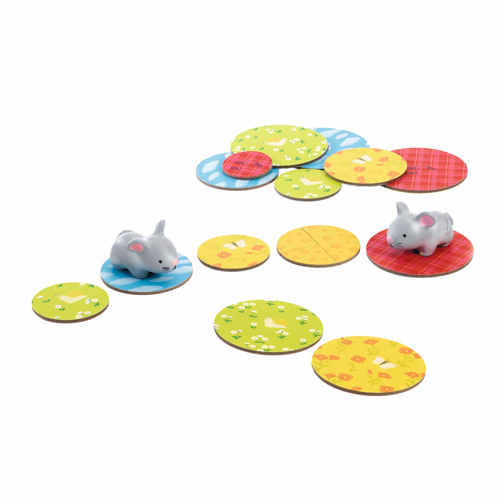 Two gray rabbit figurines on colorful circular tiles with various patterns like plaid and polka dots. The scene conveys a playful, cheerful tone.