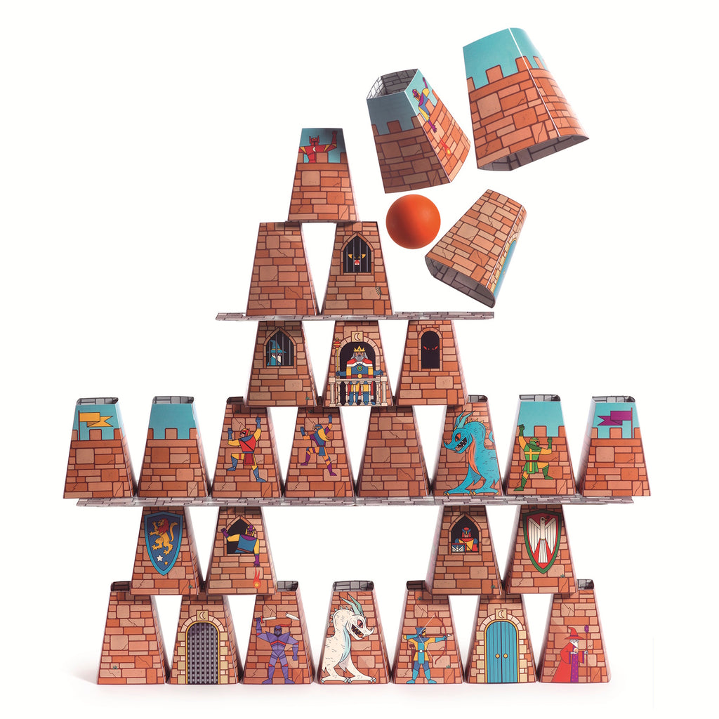 A pyramid of cardboard castle cups with medieval illustrations is being hit by an orange ball, causing two cups to topple. The scene is playful and dynamic.