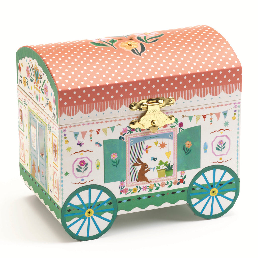 The music box is crafted in the shape of an enchanting caravan, adorned with intricate illustrations and soft pastel colors.