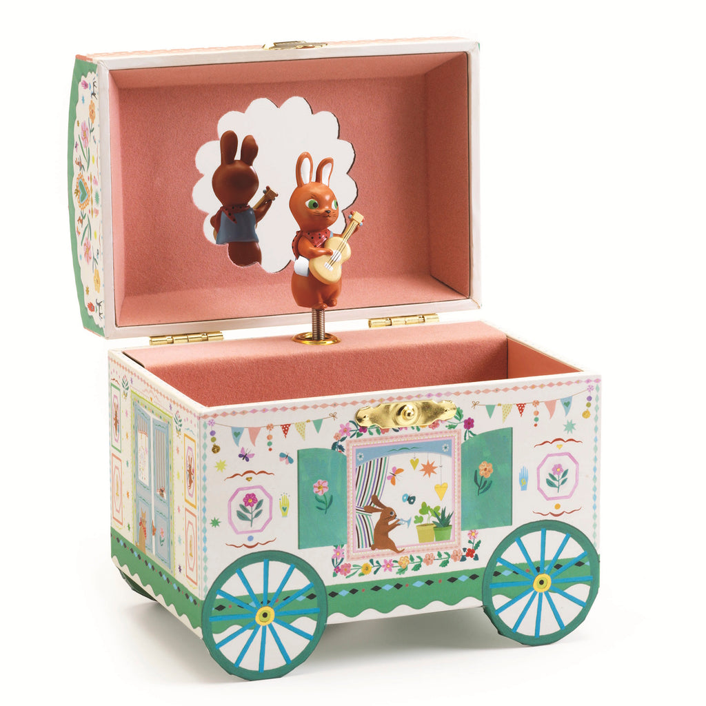 The music box is crafted in the shape of an enchanting caravan, adorned with intricate illustrations and soft pastel colors.