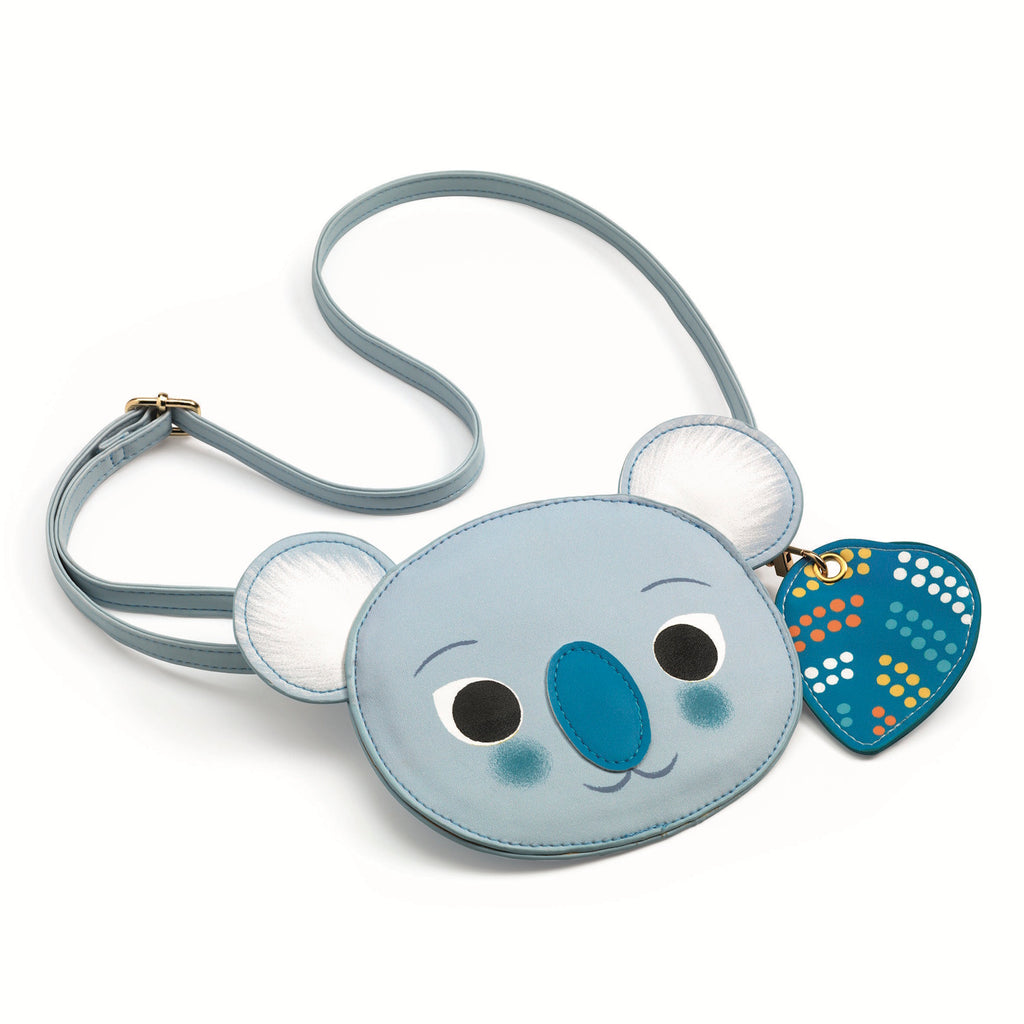 Cute koala-shaped purse with a soft blue color, big eyes, and round ears. Features a playful dotted heart-shaped charm and matching blue strap.