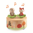 This wooden music box features a whimsical forest scene with removable figurines - a rabbit and a squirrel - that dance and spin on a magnetic top when the box is wound up.