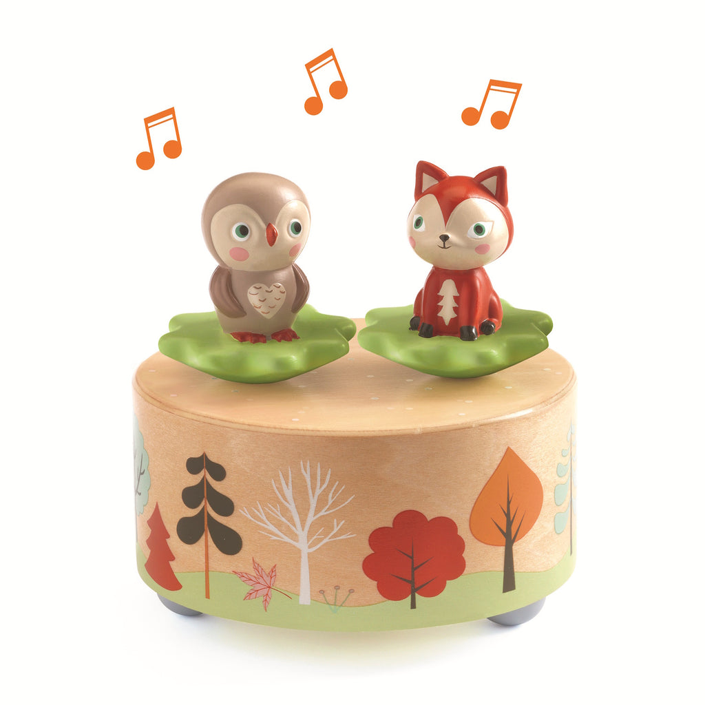 This wooden music box features a whimsical forest scene with removable figurines - a rabbit and a squirrel - that dance and spin on a magnetic top when the box is wound up.