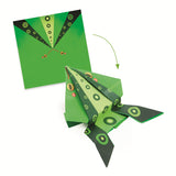 A craft kit featuring colorful paper designs and folded animal shapes like frogs and kangaroos that can hop when pressed.