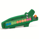 Green wooden crocodile counting toy for kids with colorful sliding discs on a white background.