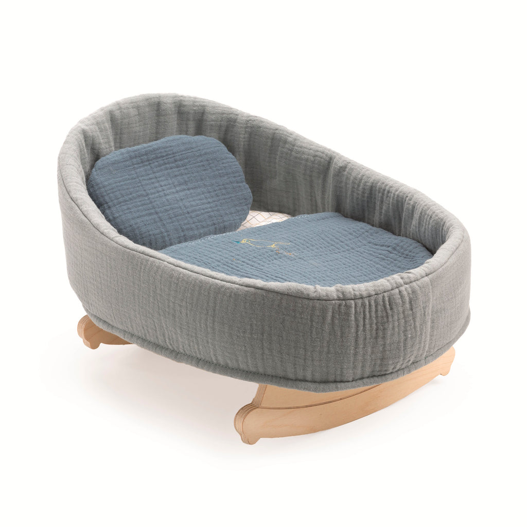 Gray fabric covered baby doll cradle with quilted fabric inside and a matching pillow, set on light wood rockers. The cradle exudes coziness and warmth.