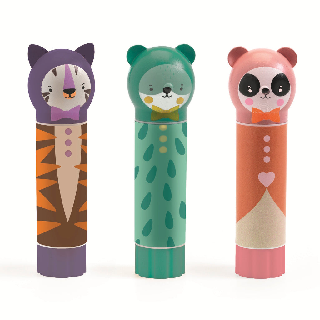 Three colorful lip balm containers designed as animals: a tiger, a bear, and a panda. Each has a bow tie and cheerful face, conveying a playful tone.