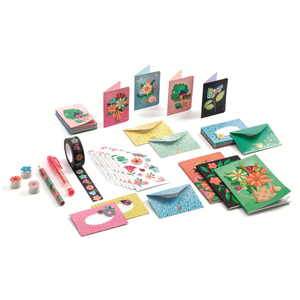 Flat lay of vibrant stationery set with floral-themed cards, envelopes, tape, and pens. Bright, cheerful designs, conveying creativity and joy.