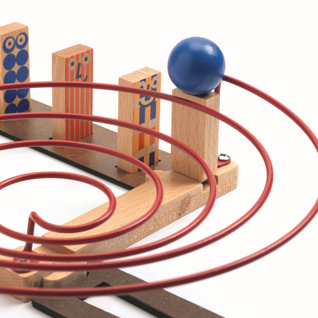 The set comprises 51 pieces, including wooden tracks, ramps, and three large wooden balls.