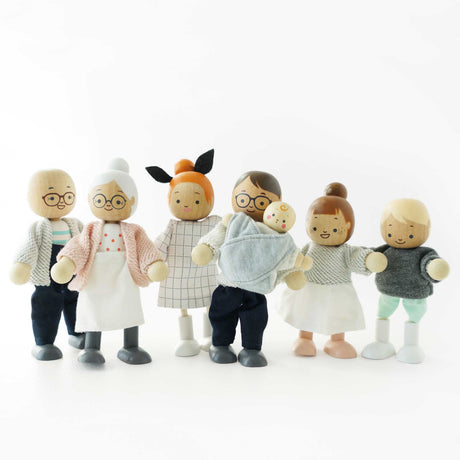 Seven wooden dollhouse family figures standing in a line against a plain white background.