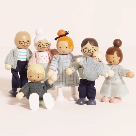 Seven wooden dollhouse family figures standing together with one child sitting in front.