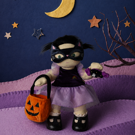 Plush doll in a cat mask holding a pumpkin bag and candy toy against a starry night backdrop.