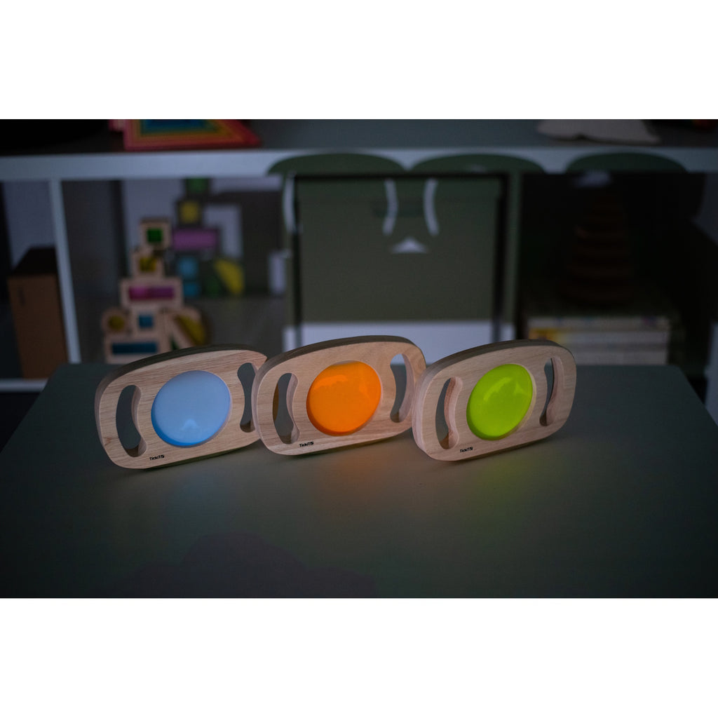 A set of handheld panels with glowing colored centers, designed for sensory play, color exploration, and visual stimulation.