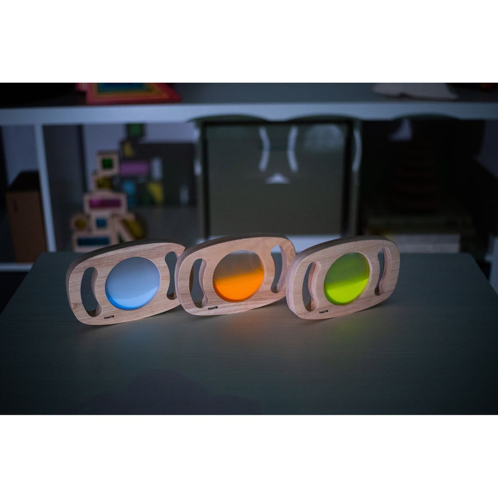 A set of handheld panels with glowing colored centers, designed for sensory play, color exploration, and visual stimulation.
