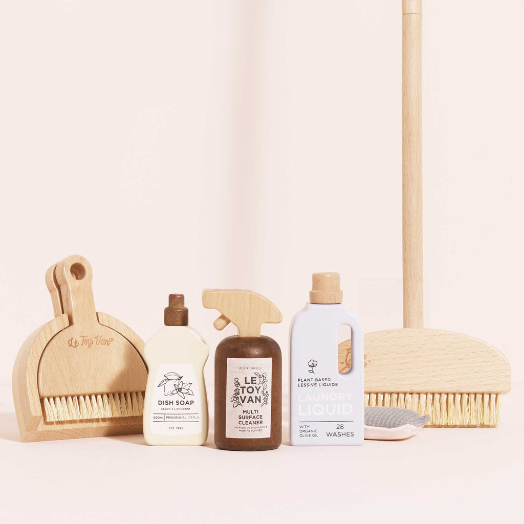 Wooden toy cleaning set featuring dish soap, multi-surface cleaner, and laundry liquid. Includes brushes and a sponge. Neutral tones, playful design.