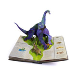 Pop-up book displaying a 3D dinosaur model standing over colorful illustrations and text about long-necked giants. The scene is vibrant and playful.