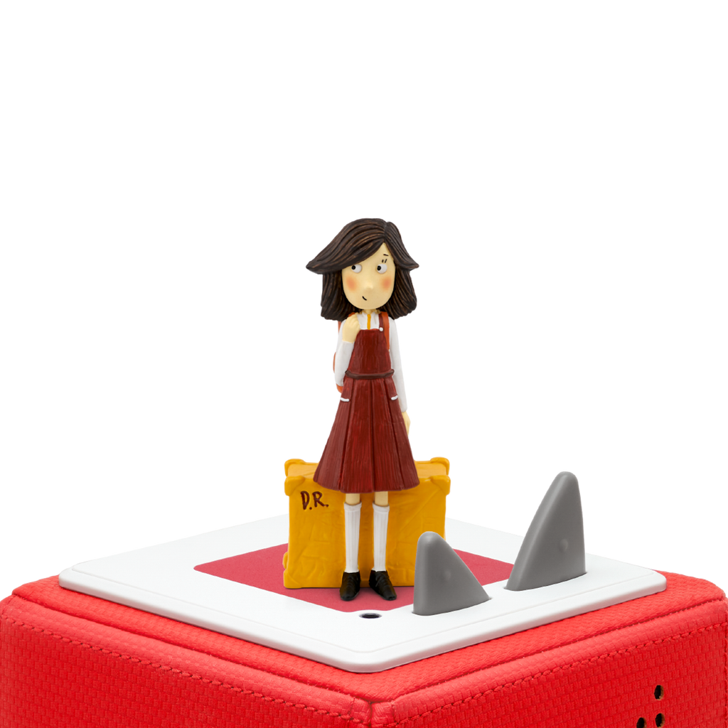 A charming figurine of a girl with brown hair, wearing a red dress and standing beside a yellow suitcase marked "D.R.".