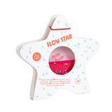 A star-shaped wooden sensory toy by Petit Boum, featuring pink glittery liquid inside, with packaging labeled "Flow Star" and "Glow in the Dark."