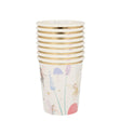 A stack of white paper cups with gold rims, illustrated with fairies, mushrooms, and flowers.