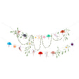 Fairy themed party garland with tissue paper mushrooms, flowers, greenery leaves, and magical fairies.