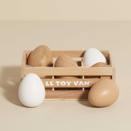 Wooden crate filled with toy eggs on a beige background.