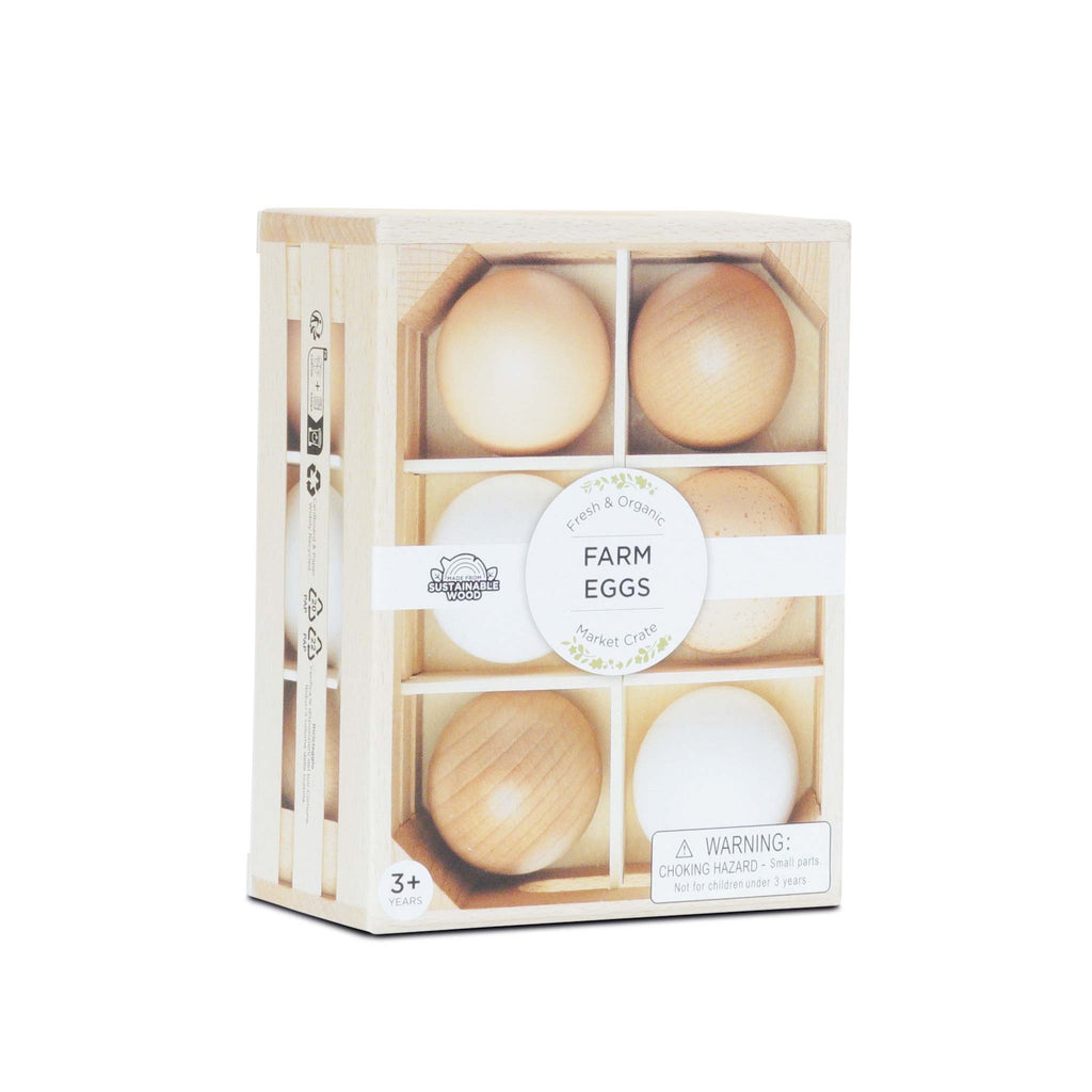 A wooden crate containing six toy eggs in various shades, labeled "Farm Eggs" with a circular tag. Includes a warning for ages 3 and up.