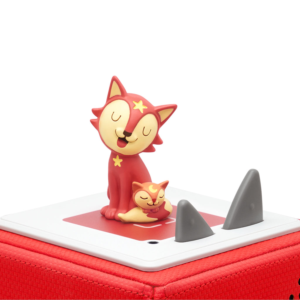 A playful red cat and its sleeping kitten figurine, exuding a whimsical charm.