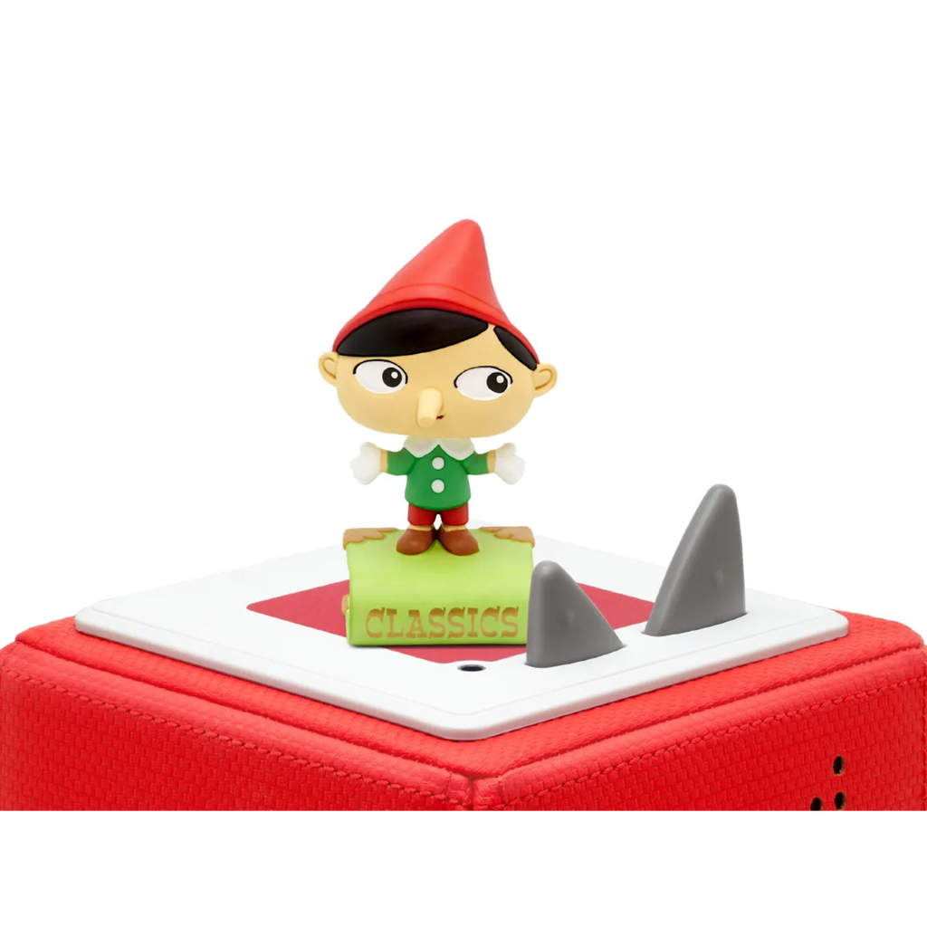 A colorful figurine of a cartoon character with a red hat, green outfit, and oversized nose, standing on a book labeled "CLASSICS" audiobook.