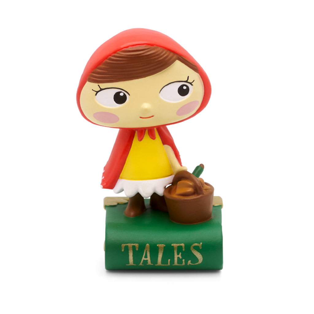 A cheerful Little Red Riding Hood figurine stands on a green book titled "Tales" audiobook in a white background. 