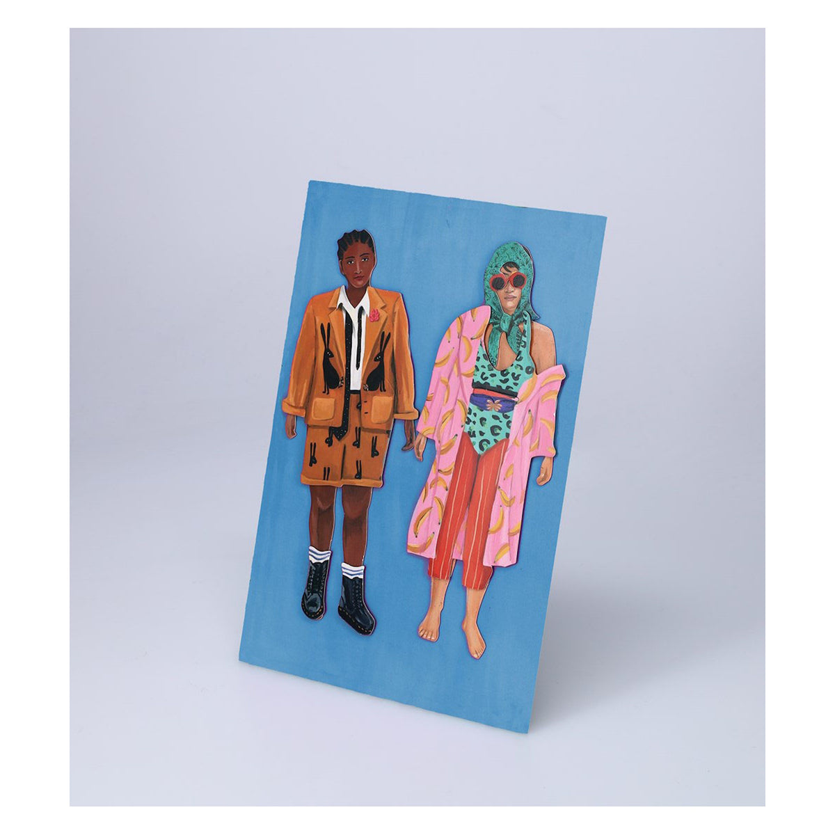 Fearless Fashion magnetic paper dolls in eclectic outfits on a blue background, featuring bold patterns and colors.