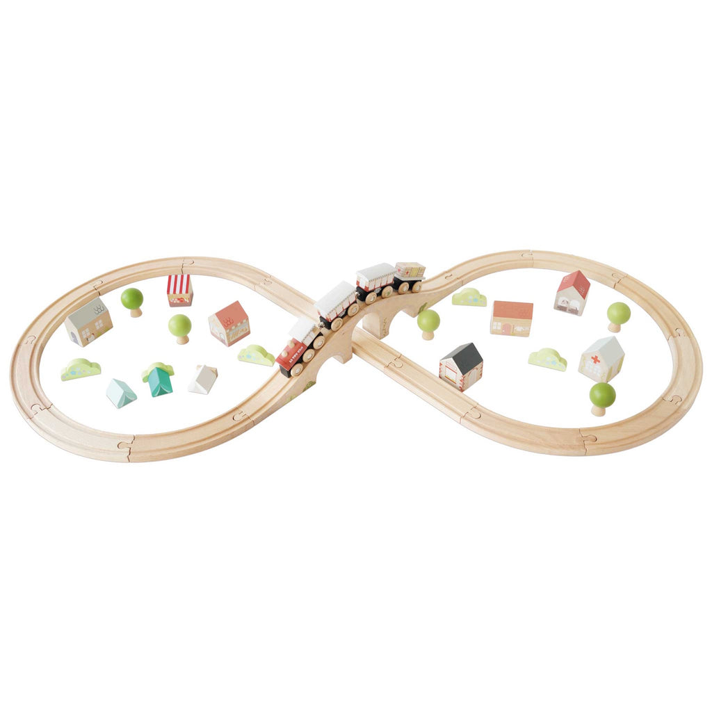Wooden toy train set with a bridge and winding tracks is surrounded by small wooden trees and houses, creating a playful village scene.