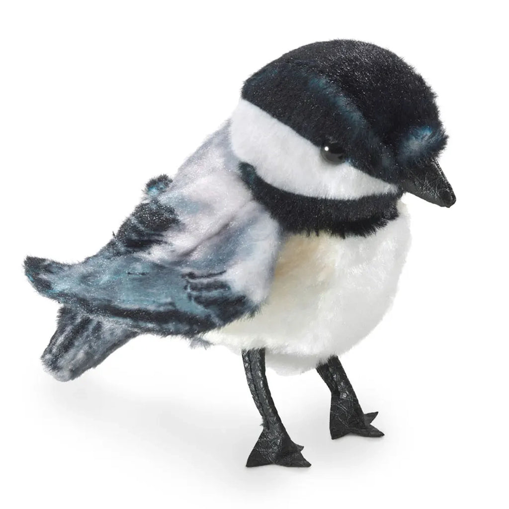 A plush toy bird with realistic detailing, featuring black, white, and blue colors. It has a soft, fluffy texture and a lifelike, gentle expression.