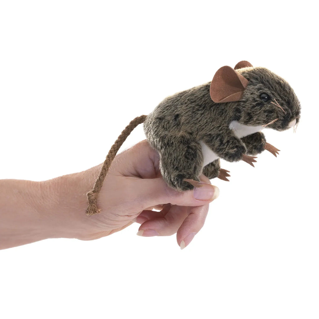 A hand holding a realistic brown mouse finger puppet with large ears and a long tail. The puppet appears lifelike and detailed, conveying playfulness.