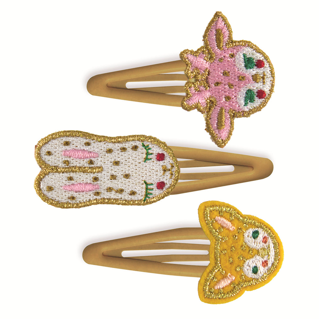 Three hair clips with gold metal bases featuring embroidered animal faces: a pink deer, a white bunny, and a yellow bear, conveying a playful and cute vibe.