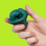 Hand holding a folded mound of dark-green focus putty against a bright lime-green background.