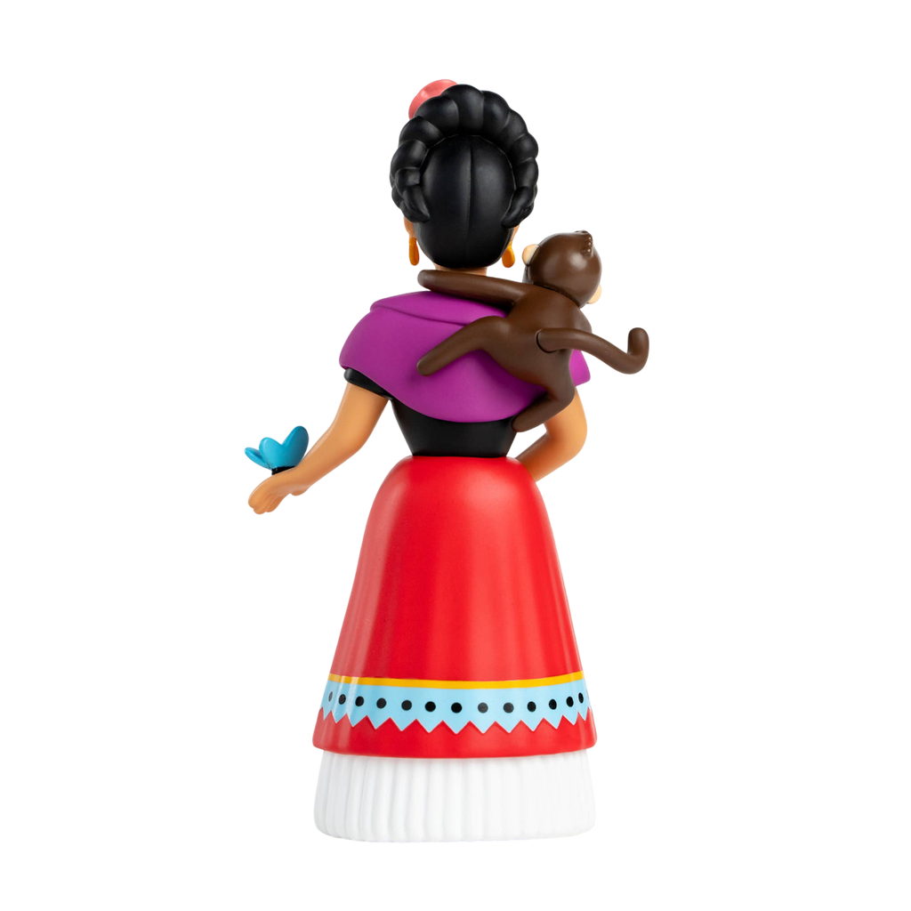 Rear view of a stylized female figurine with a braided bun, wearing a purple shawl, red skirt, and white blouse. A monkey sits on her shoulder, and a blue butterfly rests on her hand. The background is white.